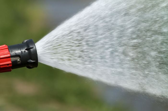 A fire hose ejects a stream of water